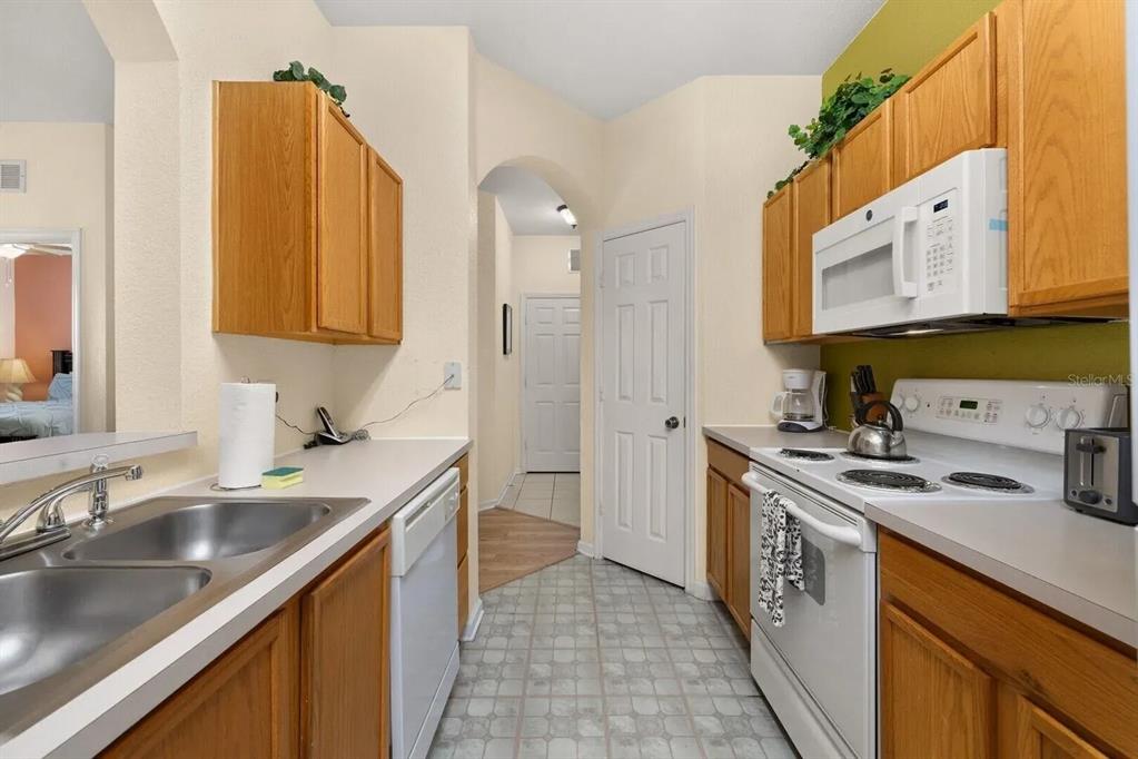 7664 Comrow Street, Unit 302 Kissimmee, FL 34747 - Photo 7 of 19 a kitchen with stainless steel appliances granite countertop a sink stove and cabinets
