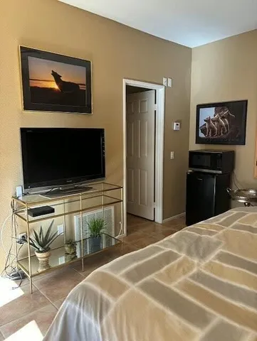 a bedroom with a bed and a flat screen tv