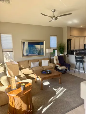 a living room with furniture a piano and a flat screen tv