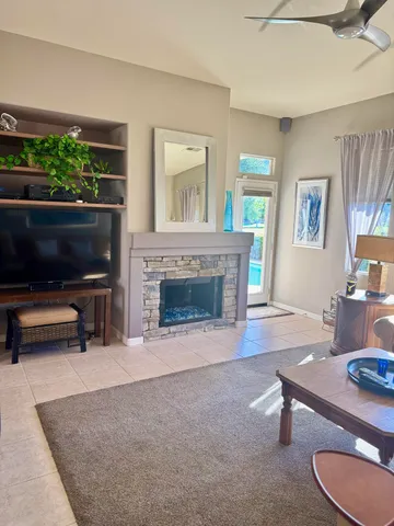 a living room with furniture a flat screen tv and a fireplace
