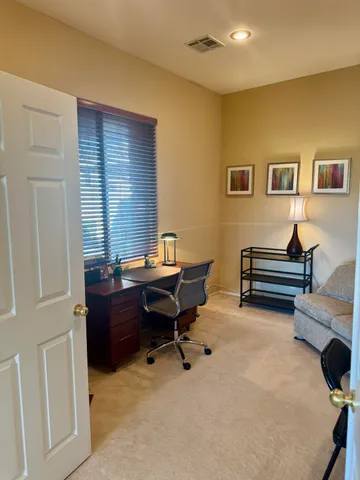 a view of a workspace with furniture and a window