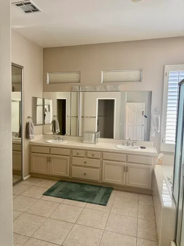 a large bathroom with a sink a large mirror and a bathtub