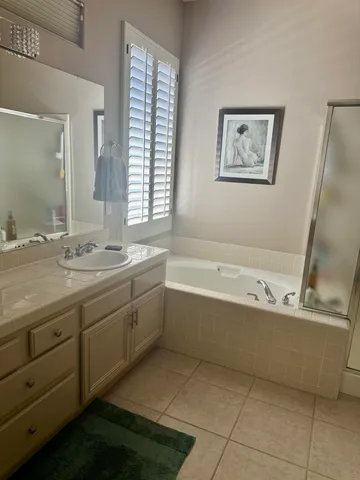 a bathroom with a tub sink and mirror