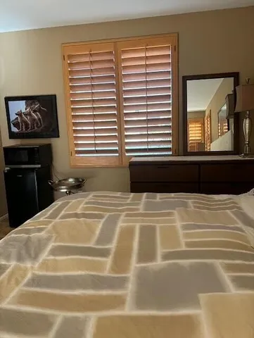 a bedroom with a bed and a large window