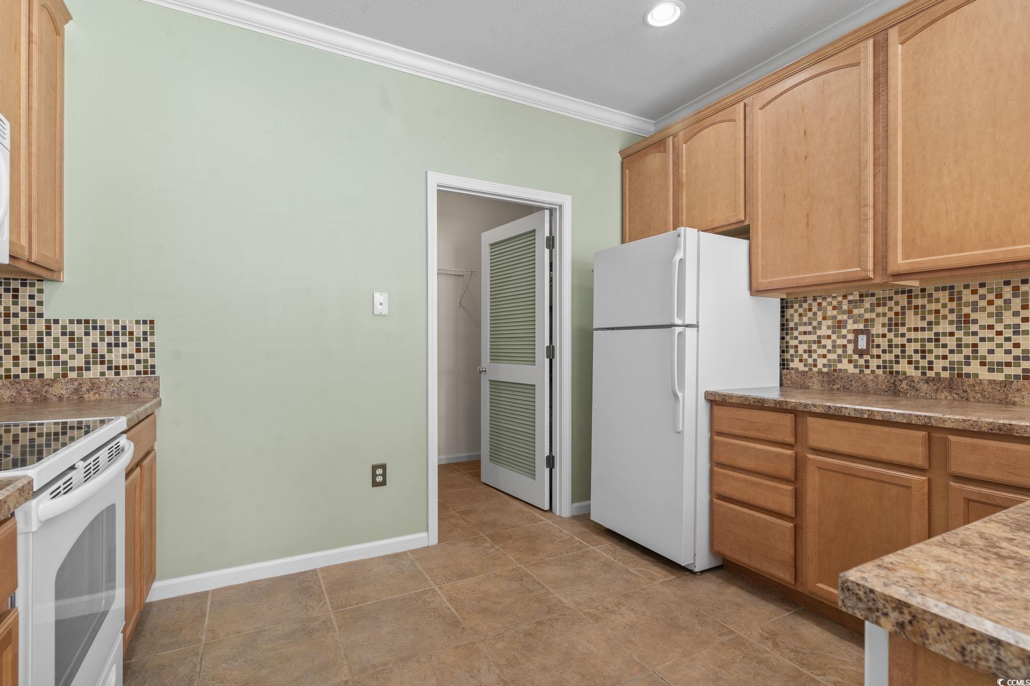 237 Moonglow Circle, Unit 102 Murrells Inlet, SC 29576 - Photo 9 of 35 Kitchen featuring tasteful backsplash, crown molding, white appliances, light tile patterned flooring, and recessed lighting