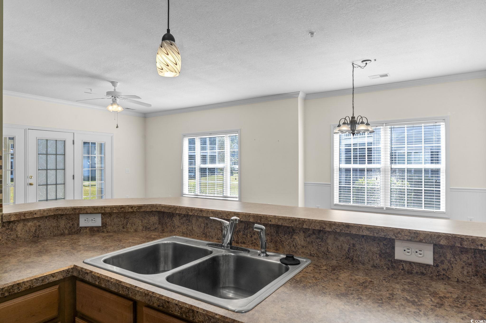 237 Moonglow Circle, Unit 102 Murrells Inlet, SC 29576 - Photo 10 of 35 Kitchen with dark countertops, ornamental molding, pendant lighting, a textured ceiling, and a ceiling fan