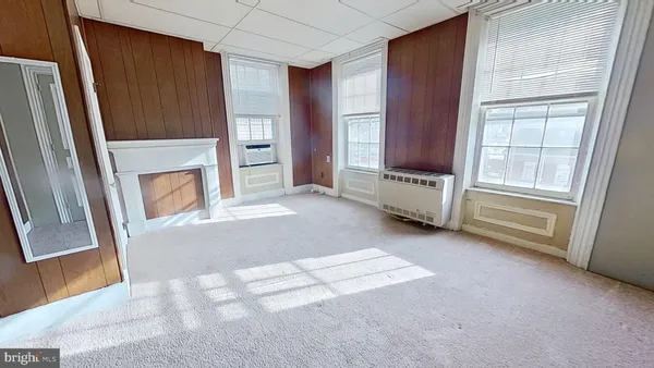a view of an empty room with a fireplace and a window