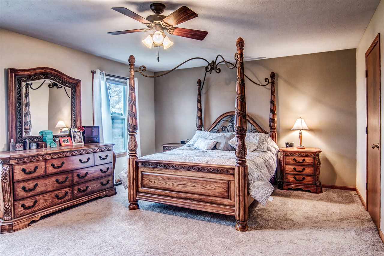 9430 Edson Road Capron, IL 61012 - Photo 11 of 25 a bedroom with a bed a chandelier and dresser