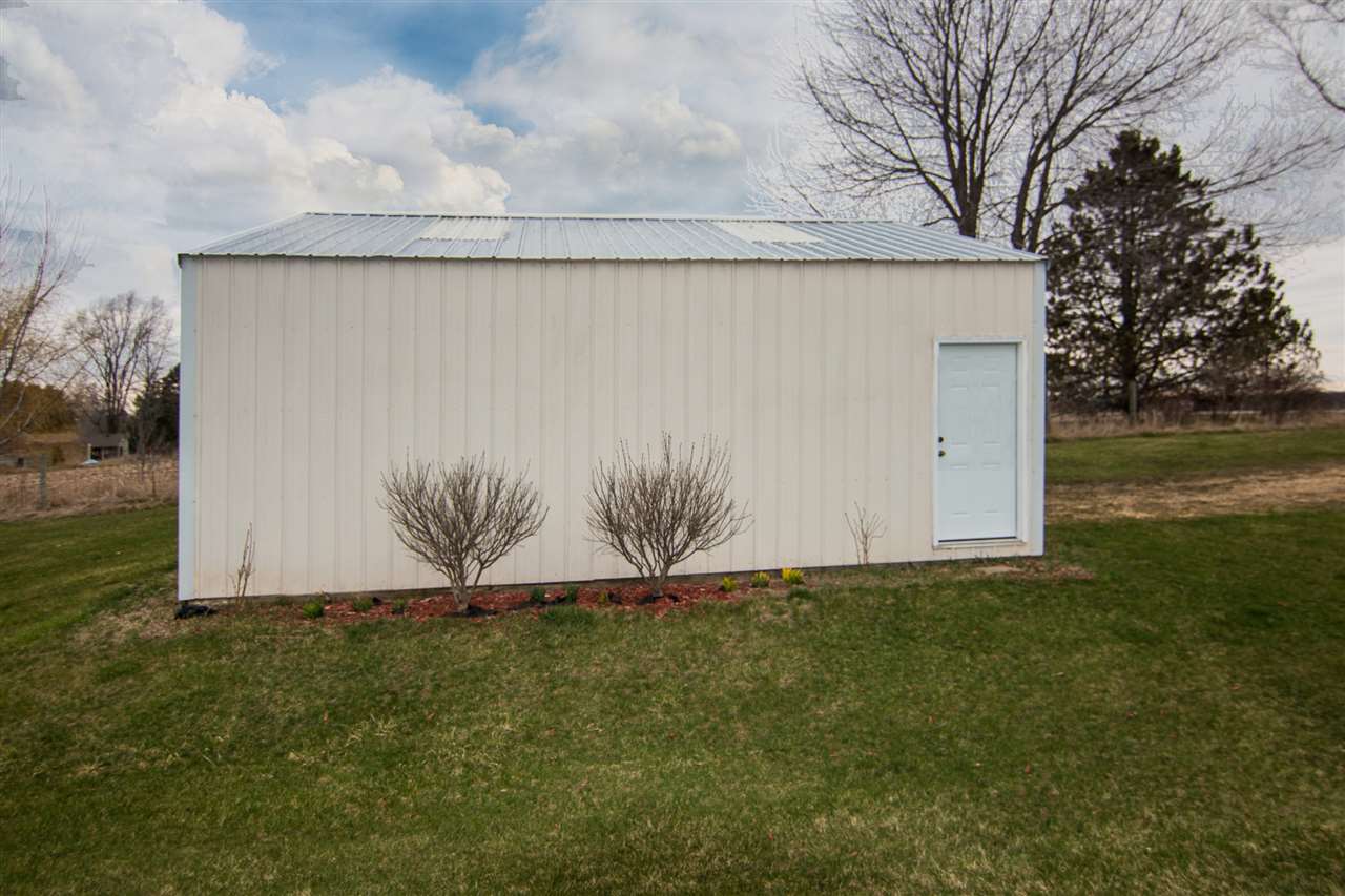 9430 Edson Road Capron, IL 61012 - Photo 23 of 25 a white house with a field and trees in the background