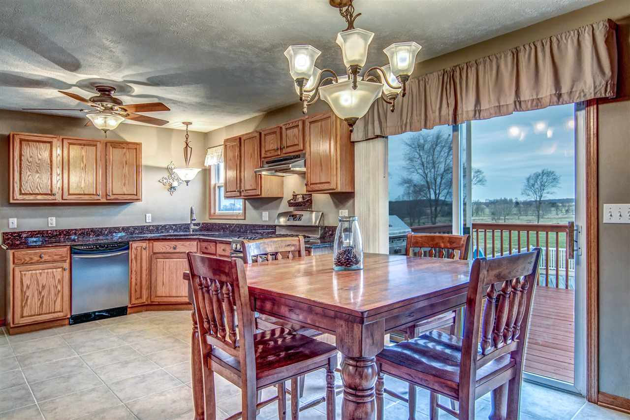 9430 Edson Road Capron, IL 61012 - Photo 7 of 25 a view of a dining room with furniture a chandelier and wooden floor