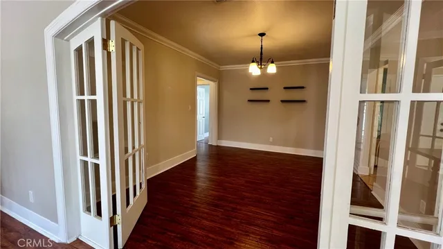 a view of a hallway with wooden floor and chandelier