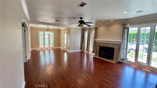 a view of a livingroom with wooden floor a fireplace and a window