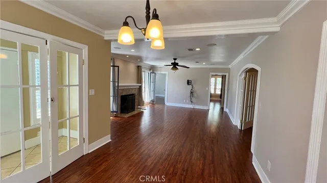a view of a hallway with wooden floor and chandelier