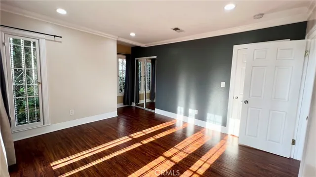 a view of an empty room with wooden floor