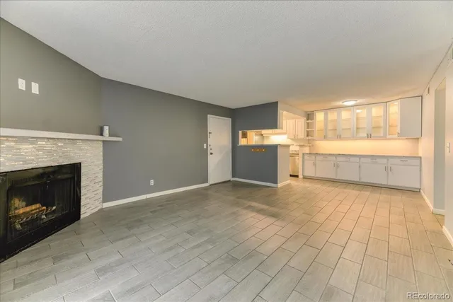 a view of a room with an empty space and a fireplace