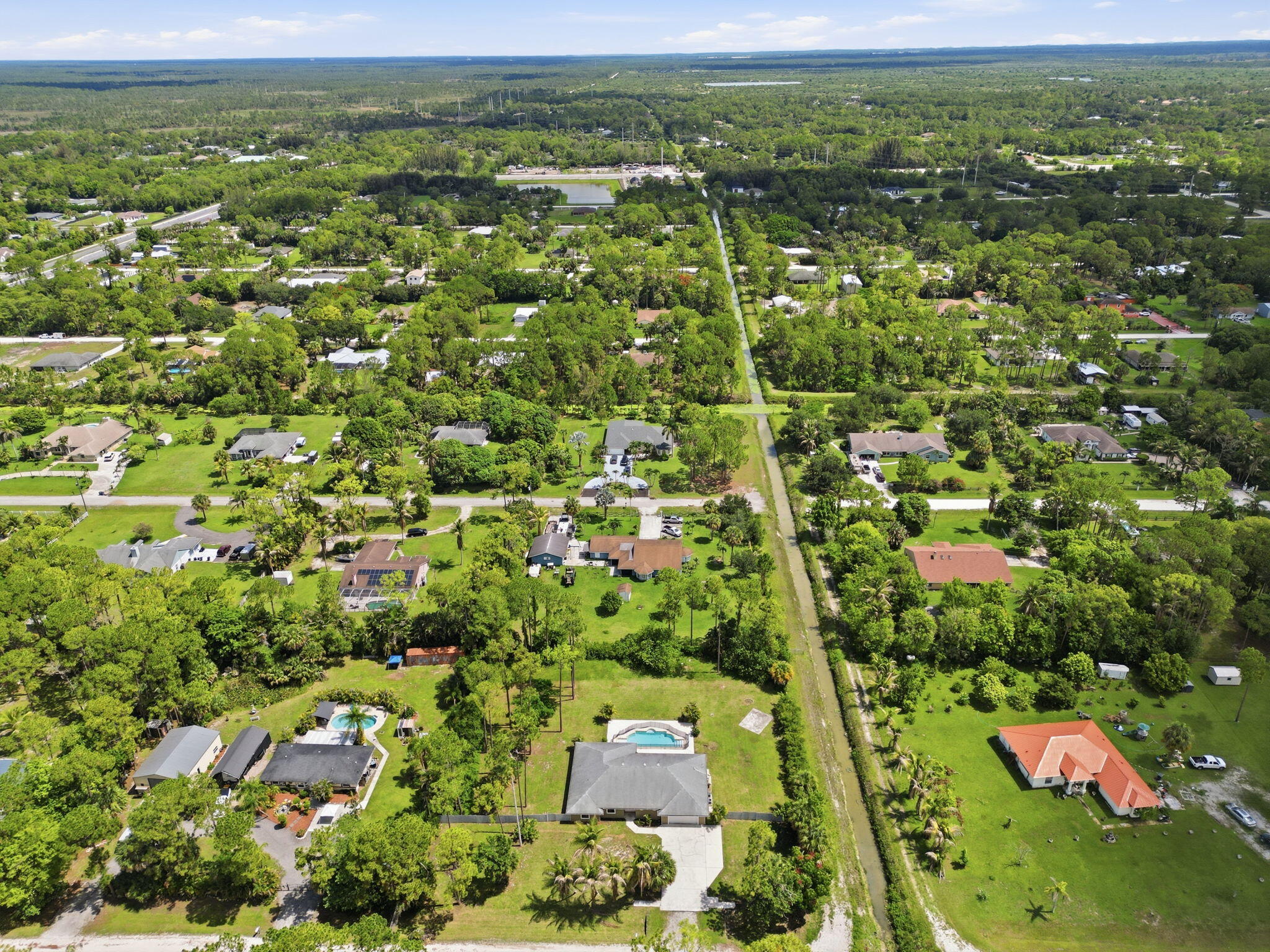 15731 85th Road North Loxahatchee, FL 33470 - Photo 56 of 65 an aerial view of residential houses with outdoor space and trees