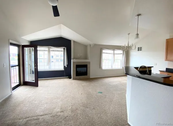 a view of an empty room with a window and fireplace