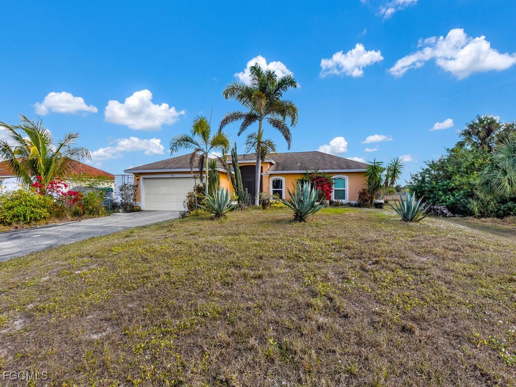 4370 20th Street Northeast Naples, FL 34120 - Photo 3 of 35 a front view of a house with a yard and potted plants