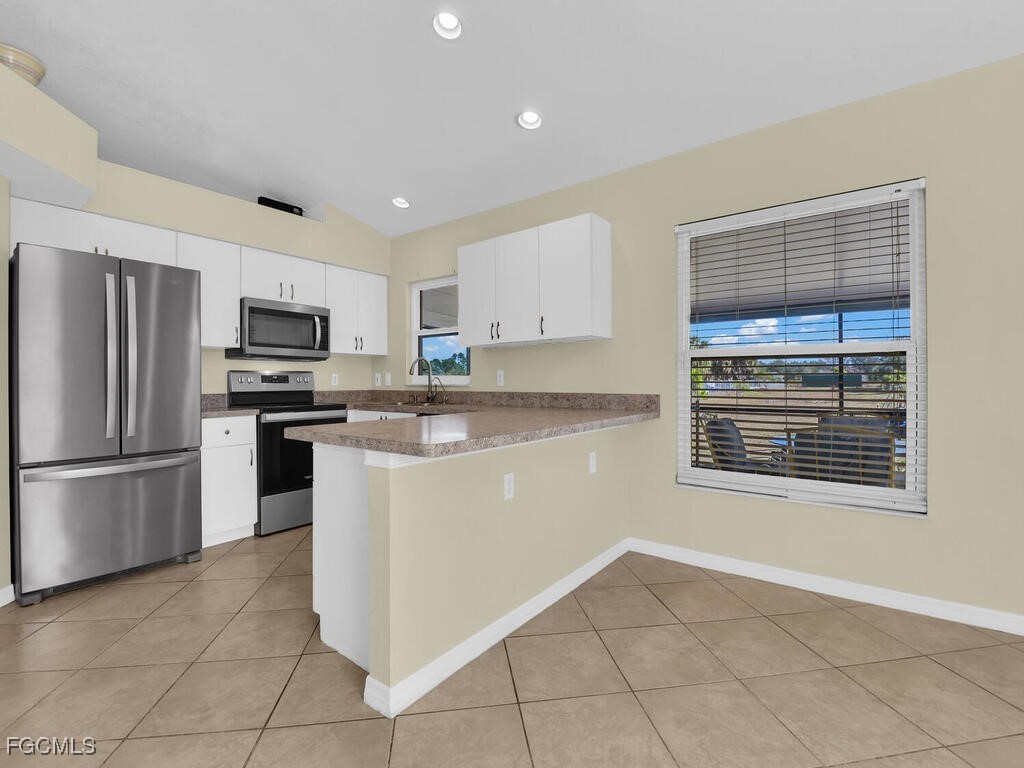4370 20th Street Northeast Naples, FL 34120 - Photo 5 of 35 a kitchen with stainless steel appliances granite countertop a refrigerator sink and stove