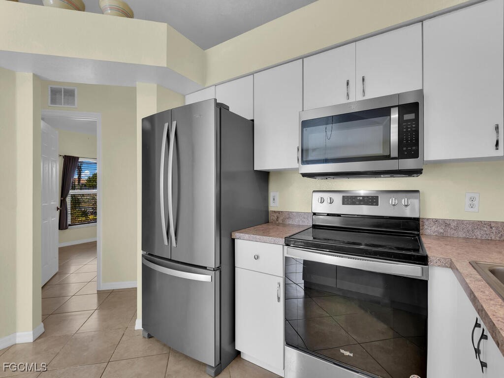 4370 20th Street Northeast Naples, FL 34120 - Photo 6 of 35 a kitchen with cabinets and stainless steel appliances