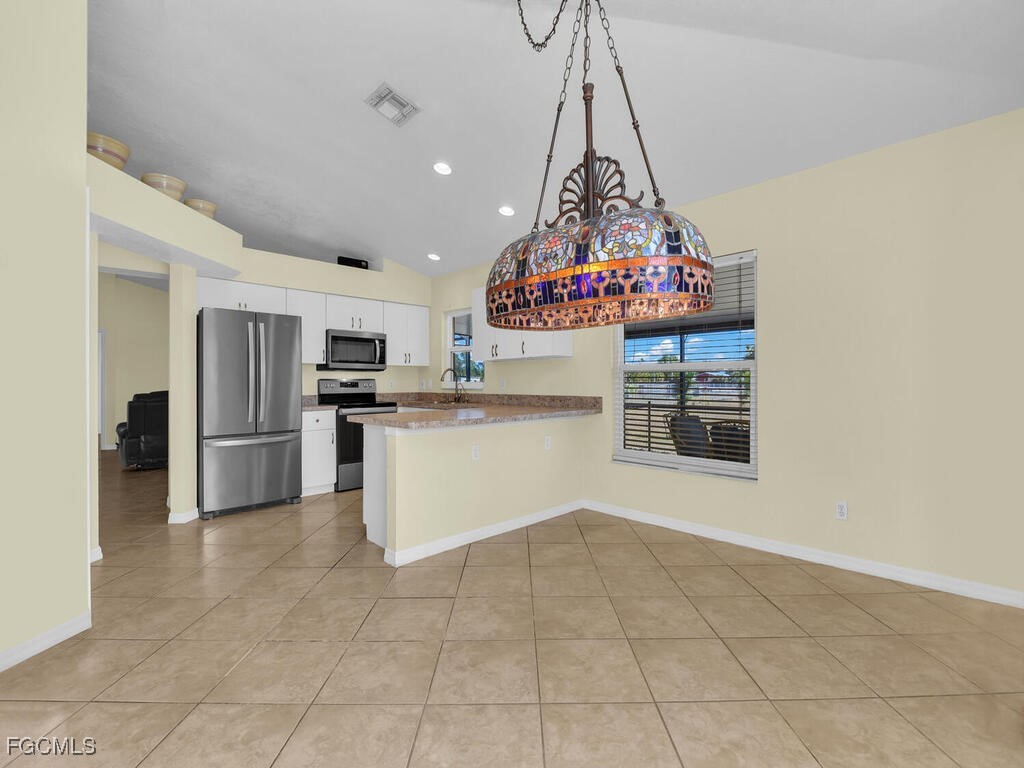 4370 20th Street Northeast Naples, FL 34120 - Photo 8 of 35 a kitchen with stainless steel appliances granite countertop a stove a sink and a refrigerator