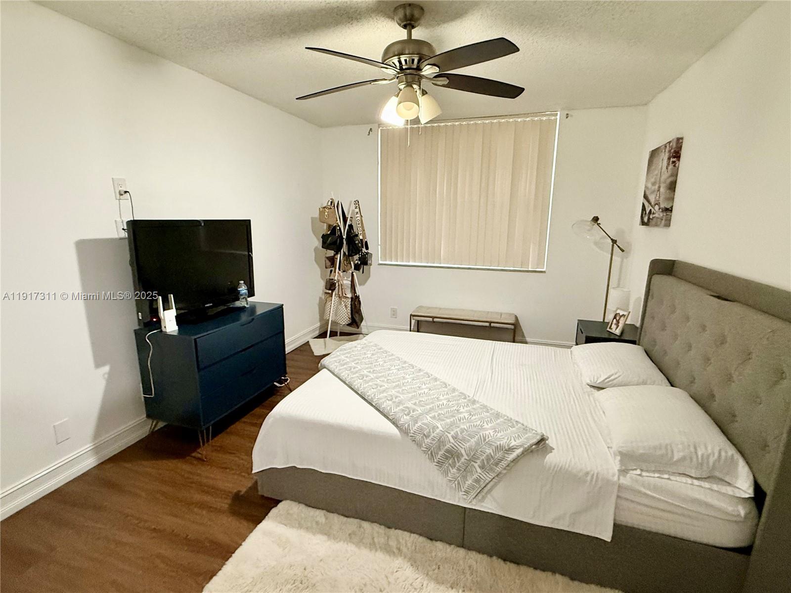 8246 Northwest 24th Street, Unit 8246 Coral Springs, FL 33065 - Photo 14 of 27 a bedroom with a bed and a flat screen tv