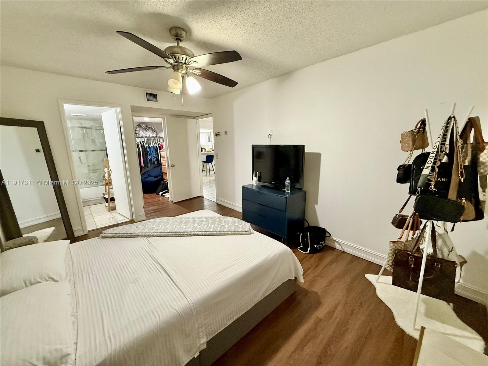 8246 Northwest 24th Street, Unit 8246 Coral Springs, FL 33065 - Photo 16 of 27 a bedroom with a bed and a flat screen tv