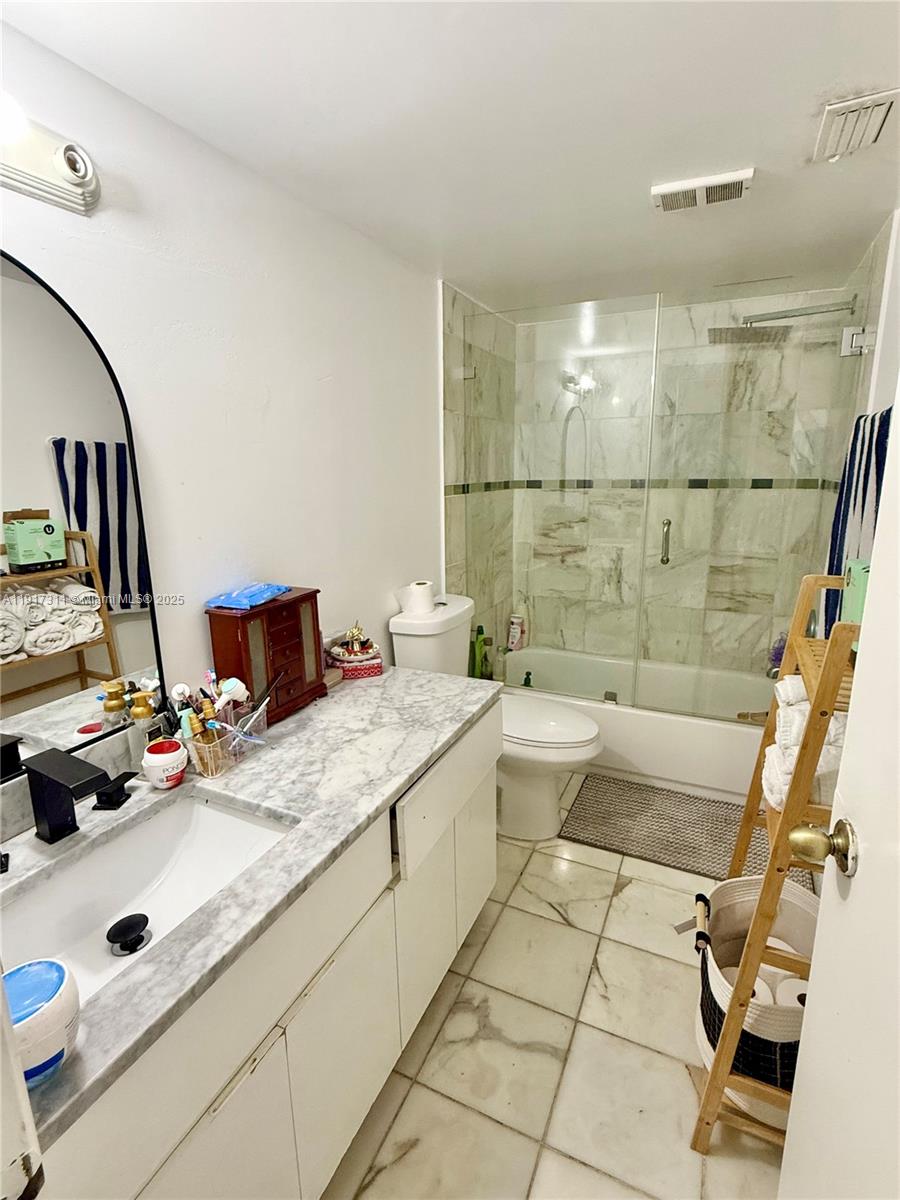 8246 Northwest 24th Street, Unit 8246 Coral Springs, FL 33065 - Photo 17 of 27 a bathroom with a double vanity sink a toilet and mirror