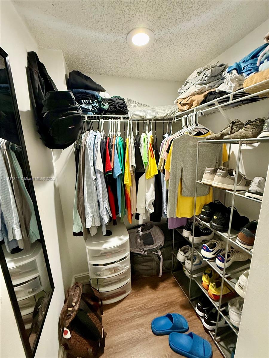 8246 Northwest 24th Street, Unit 8246 Coral Springs, FL 33065 - Photo 20 of 27 a view of walk in closet with clothes and shoes