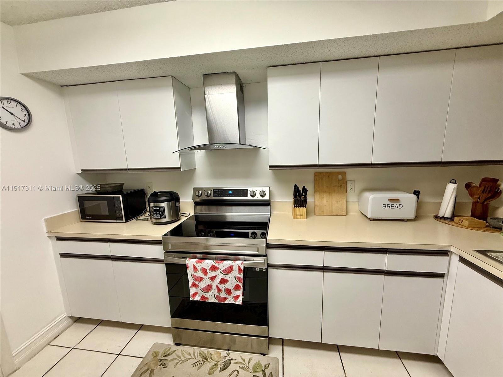 8246 Northwest 24th Street, Unit 8246 Coral Springs, FL 33065 - Photo 5 of 27 a kitchen with stainless steel appliances granite countertop a stove a sink and white cabinets