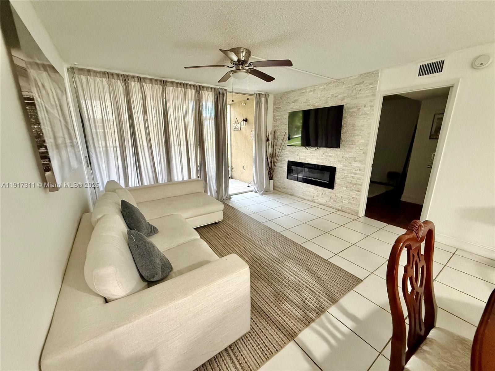 8246 Northwest 24th Street, Unit 8246 Coral Springs, FL 33065 - Photo 10 of 27 a living room with furniture a flat screen tv and a fireplace