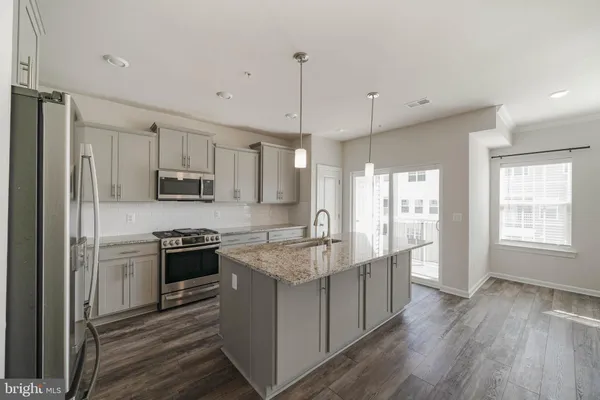 a kitchen with granite countertop cabinets and wooden floor