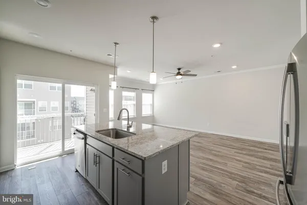 a large kitchen with kitchen island a sink dishwasher a stove and a refrigerator with wooden floor