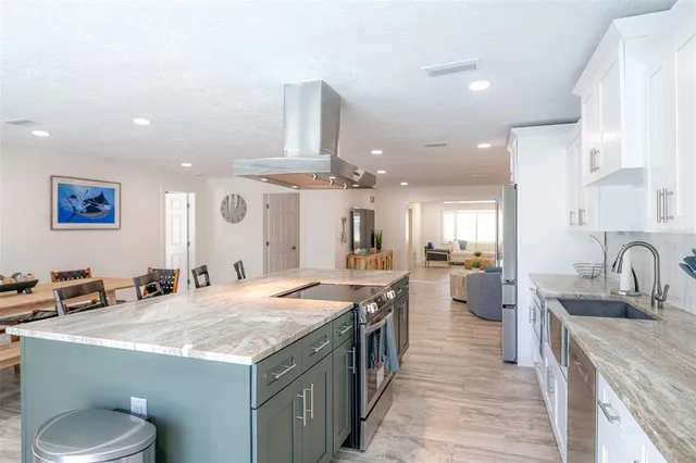 a kitchen with stainless steel appliances granite countertop a sink a stove and a refrigerator