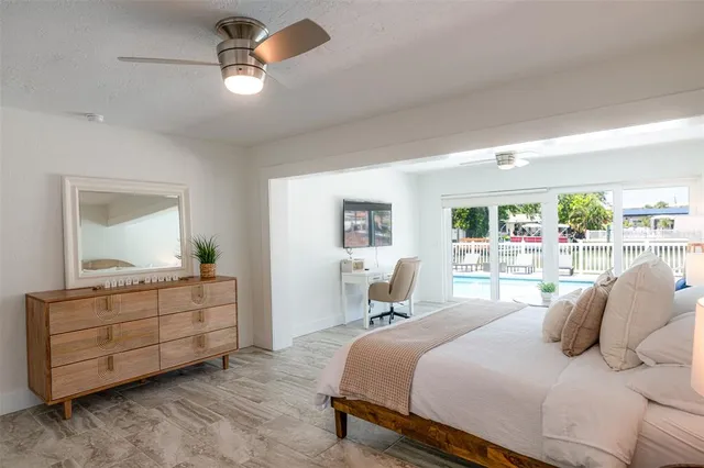 a bedroom with a large bed and a flat tv screen