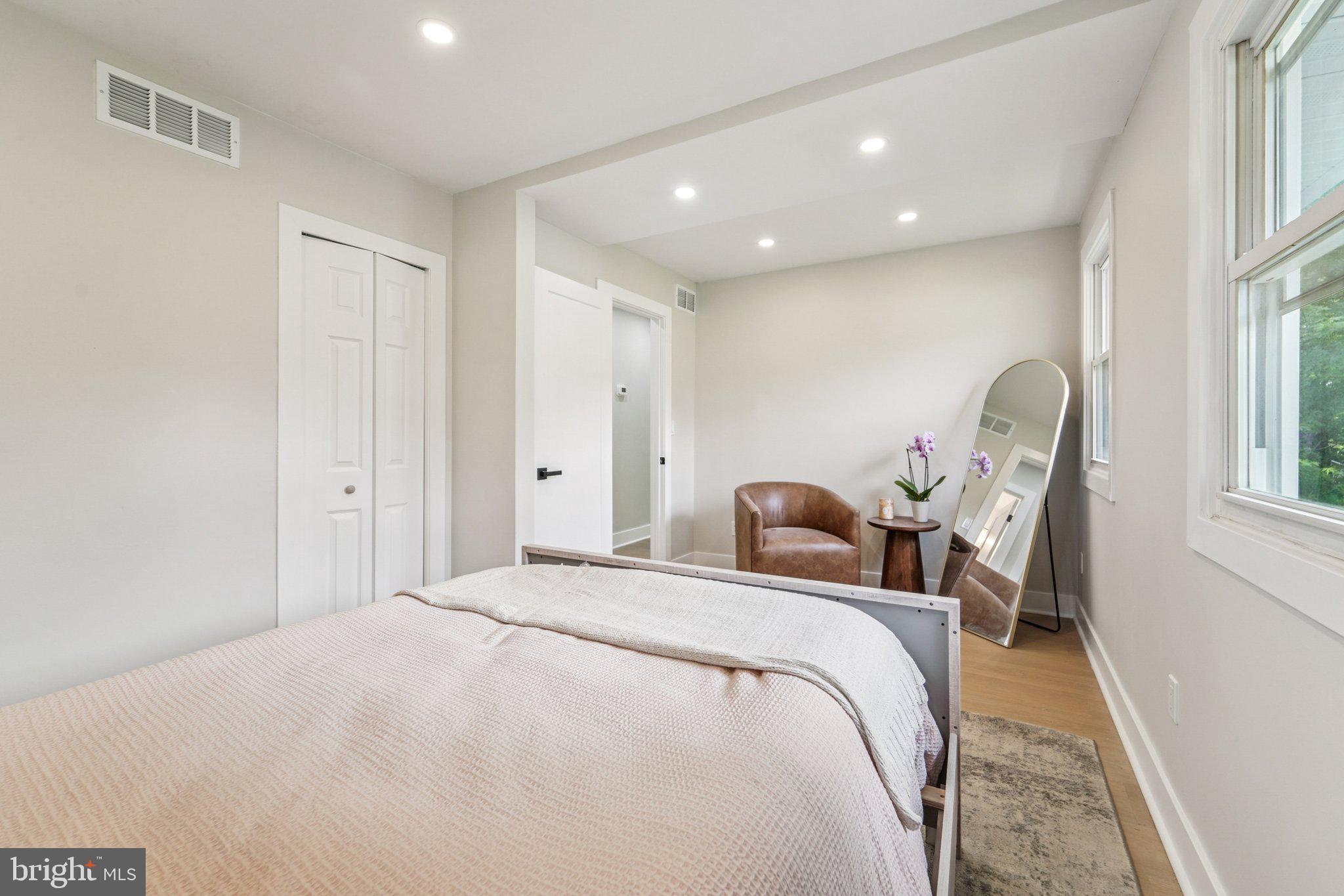 9168 Fort Smallwood Road Pasadena, MD 21122 - Photo 11 of 42 a bedroom with a bed large window and chair