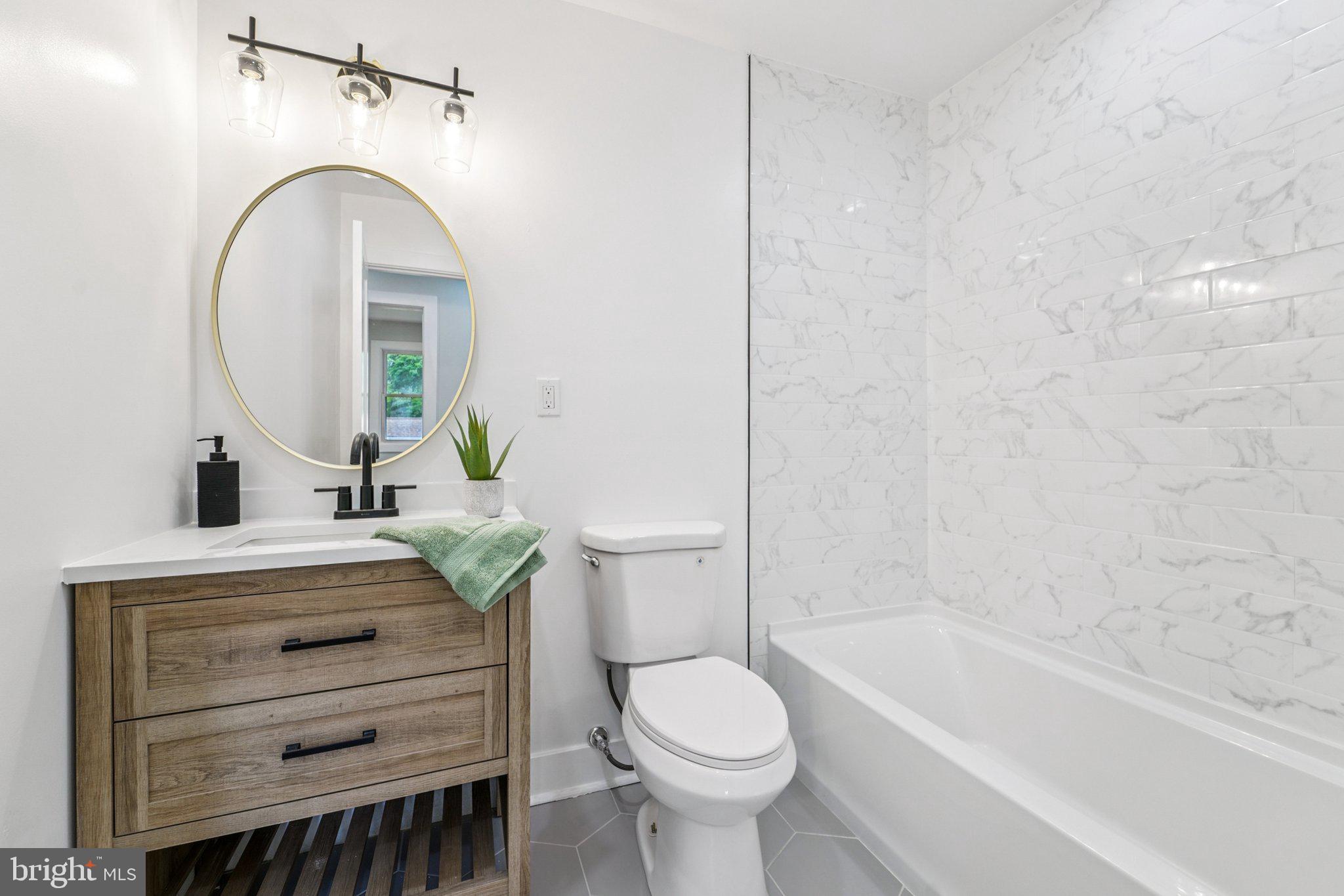 9168 Fort Smallwood Road Pasadena, MD 21122 - Photo 12 of 42 a bathroom with a sink a toilet and a bathtub