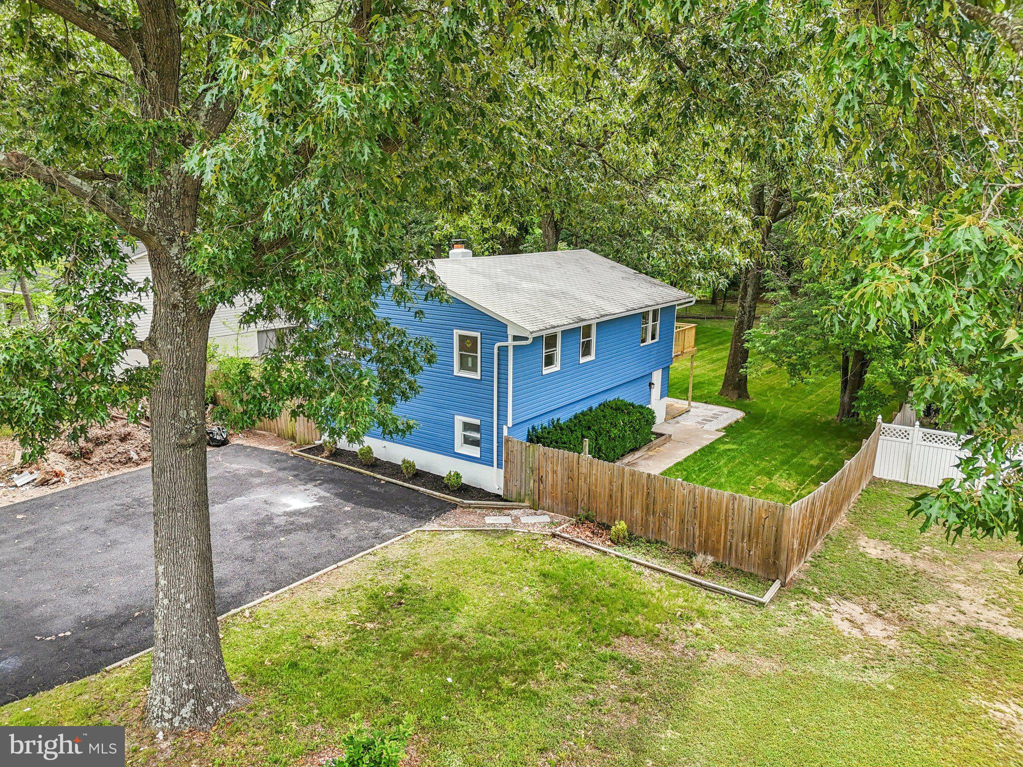 9168 Fort Smallwood Road Pasadena, MD 21122 - Photo 26 of 42 a view of a house with backyard and a tree