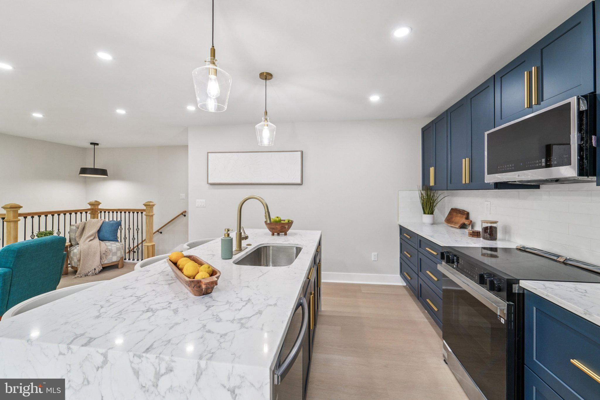 9168 Fort Smallwood Road Pasadena, MD 21122 - Photo 4 of 42 a kitchen with kitchen island granite countertop a sink a counter space appliances and cabinets