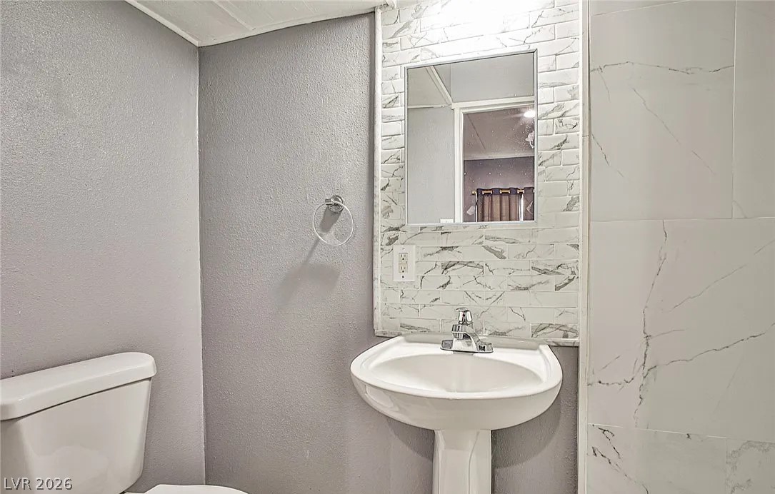 15 Washington Way Henderson, NV 89015 - Photo 2 of 9 Half bathroom featuring a textured wall and tile walls