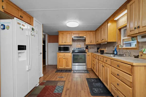 a kitchen with granite countertop a refrigerator and a stove top oven