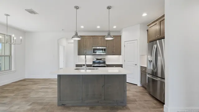 a kitchen with granite countertop a sink stainless steel appliances and cabinets