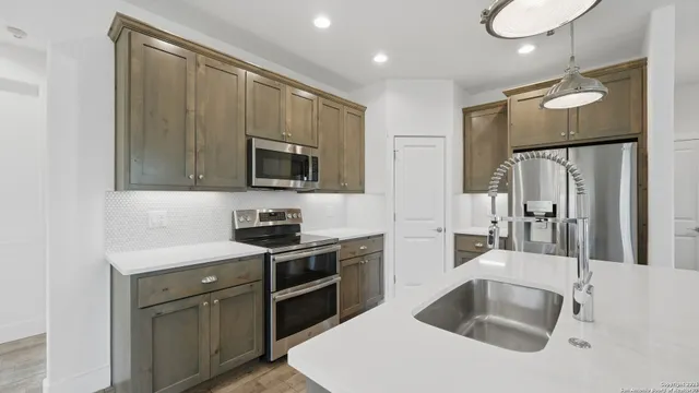 a kitchen with a sink appliances and cabinets