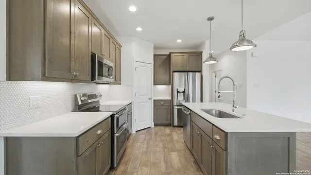 a kitchen with a sink a chandelier and a fireplace