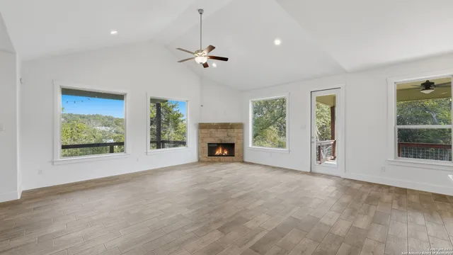 a view of kitchen and empty room with a fireplace