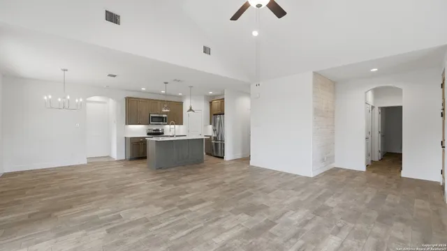 a kitchen with kitchen island a counter top space stainless steel appliances and a chandelier