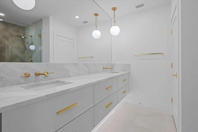 a spacious bathroom with a granite countertop sink a mirror and a shower