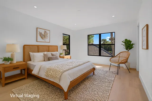 a bedroom with a bed a couch and paintings on the wall