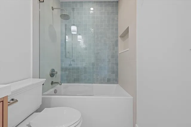 a bathroom with a bathtub shower and toilet