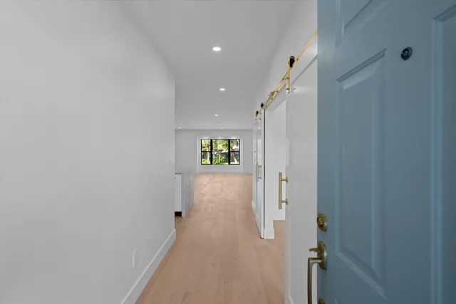 a view of hallway with stairs and wooden floor